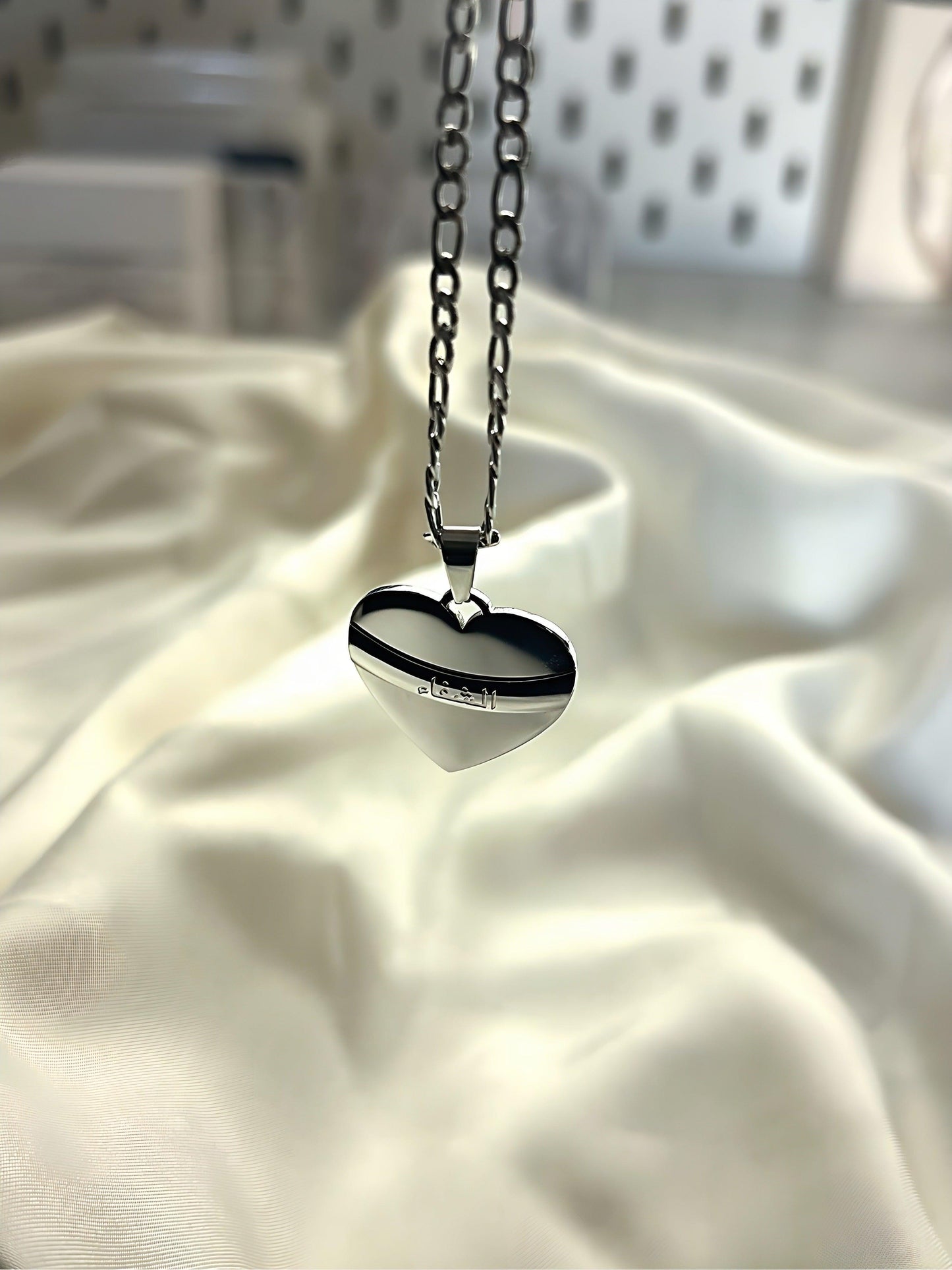 A heart shaped pendant, carved with Arabic writing meaning healing. Arabic jewellery.